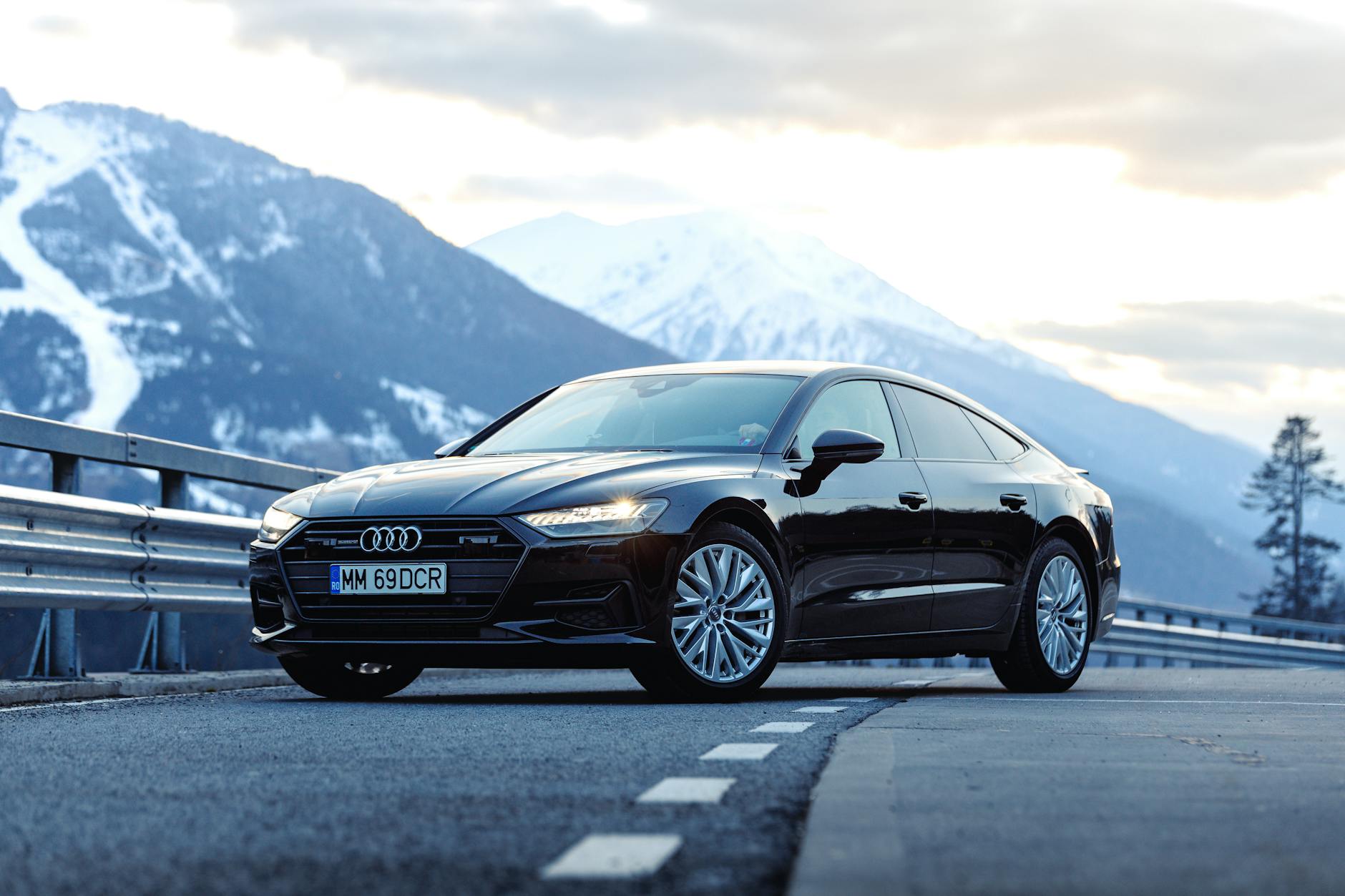 Czarne Ferrari na górskiej drodze w Rumunii na tle ośnieżonych szczytów