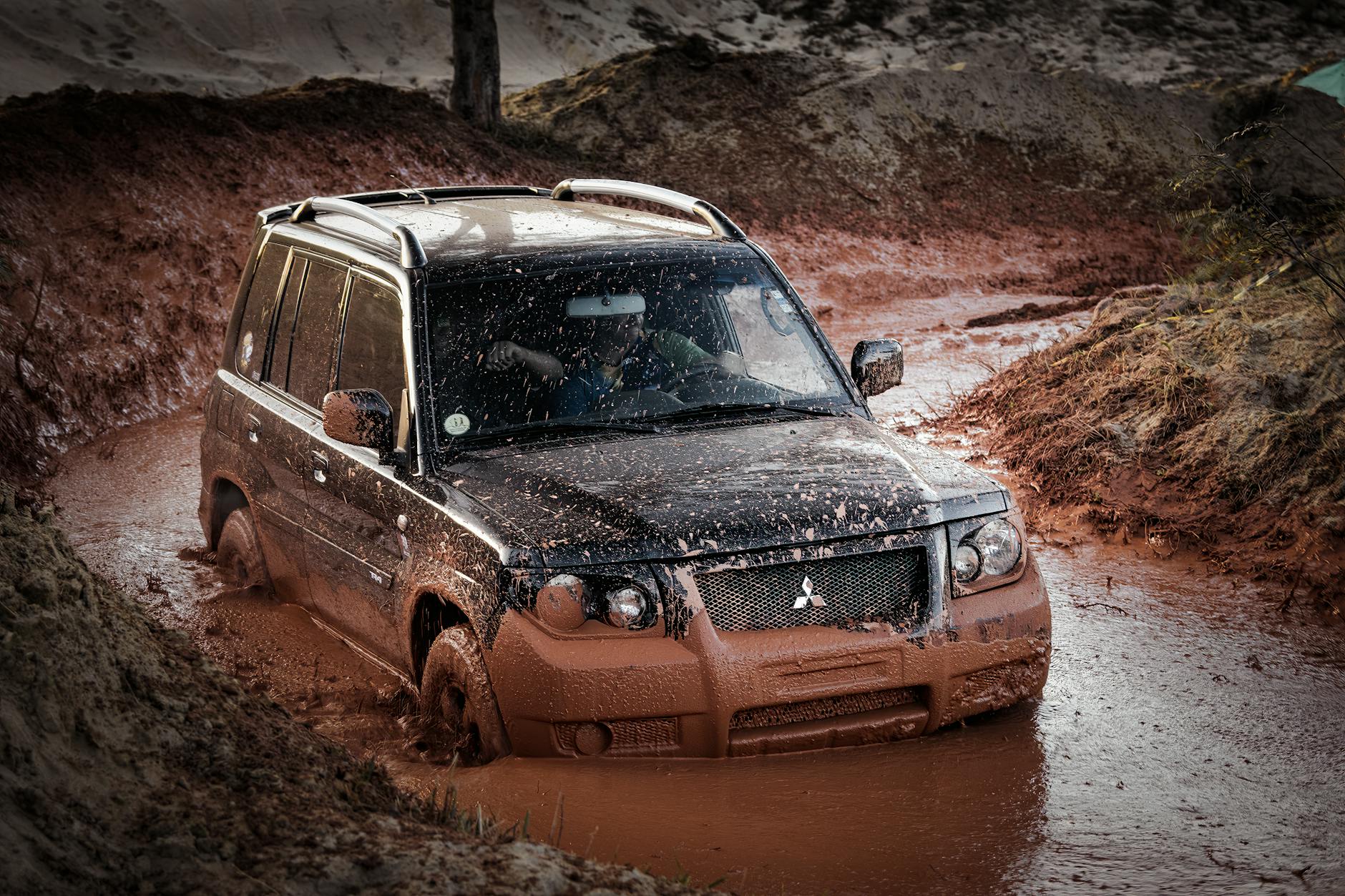 Mitsubishi SUV jadący po błotnistym, górskim bezdrożu