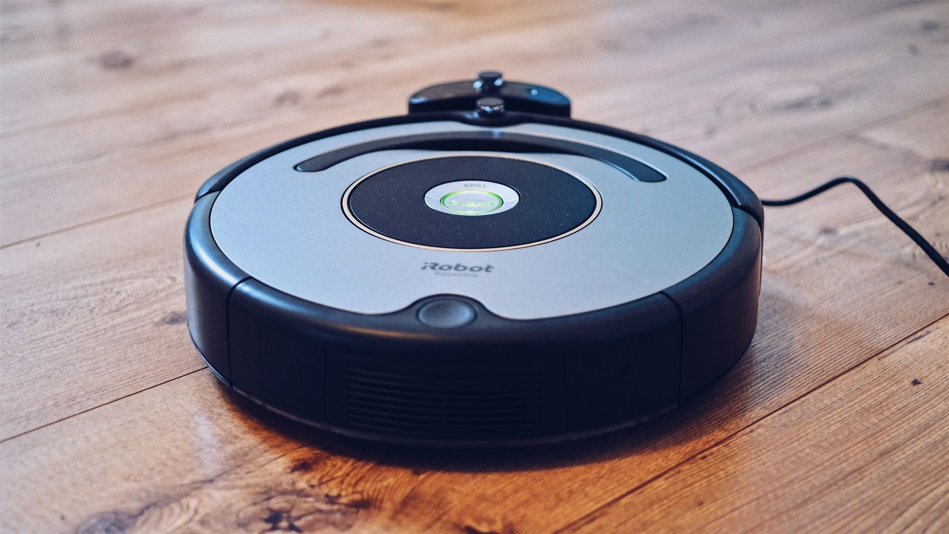 Robot sprzątający odkurza drewnianą podłogę z bliska