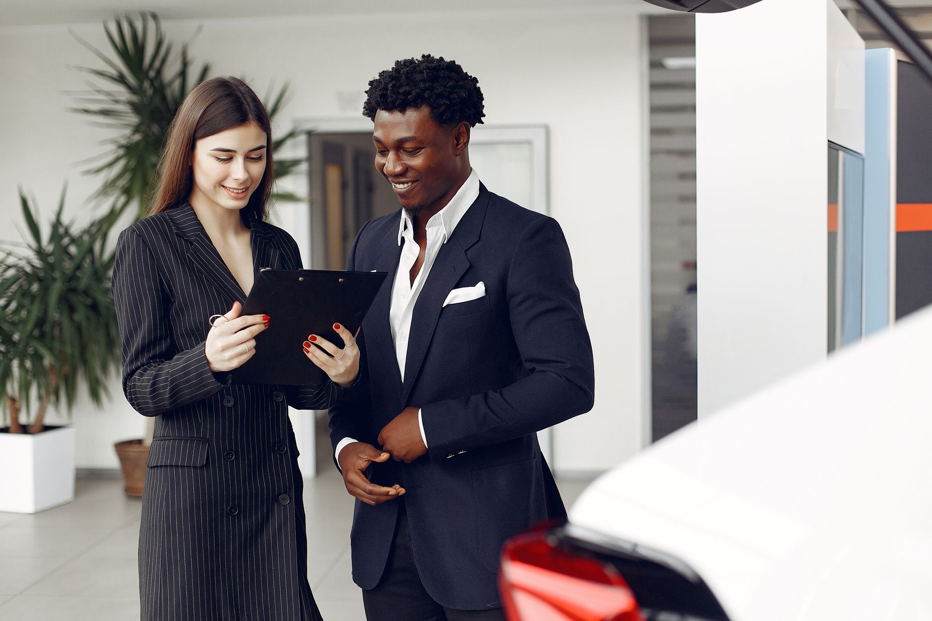 Agentka omawia umowę leasingu Maserati z klientem w salonie samochodowym